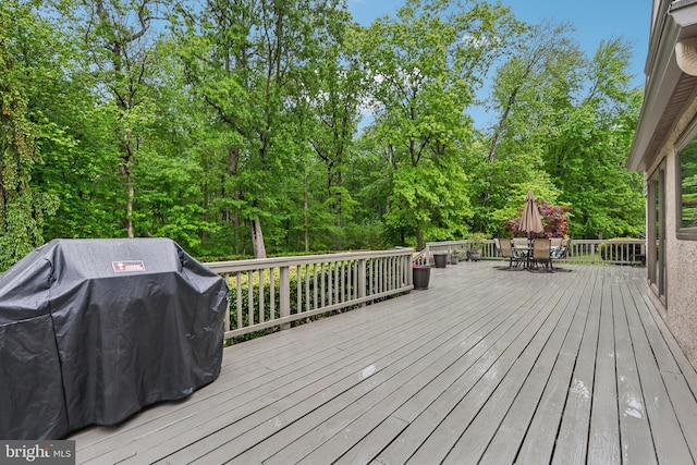 deck with a grill and outdoor dining space