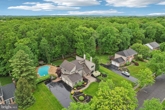 aerial view of a heavily wooded area and a pool area