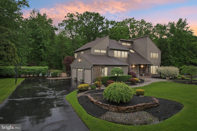mid-century inspired home featuring asphalt driveway and a lawn