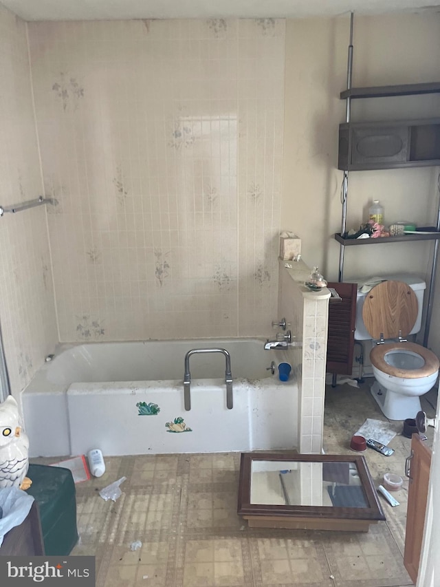 bathroom featuring a tub to relax in and toilet
