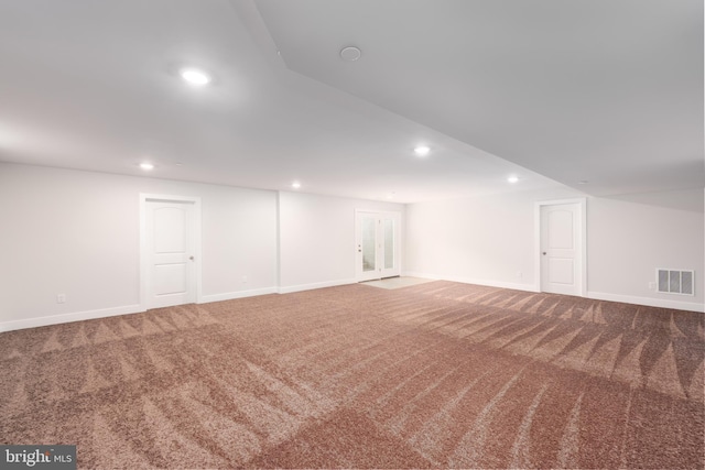 basement featuring carpet floors, baseboards, recessed lighting, and visible vents