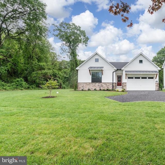 modern inspired farmhouse with an attached garage, a front lawn, stone siding, a standing seam roof, and driveway