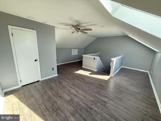 bonus room with baseboards, lofted ceiling, wood finished floors, and ceiling fan