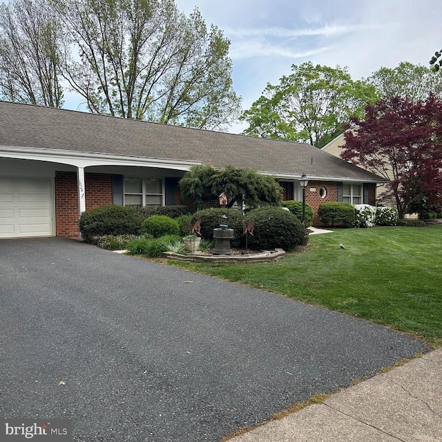 single story home with brick siding, an attached garage, driveway, and a front yard