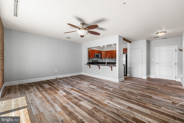 1000 Fell St Unit 633, Baltimore, MD 21231 - unfurnished living room with ceiling fan, wood finished floors, and baseboards