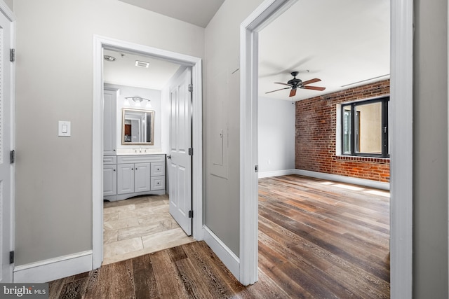1000 Fell St Unit 633, Baltimore, MD 21231 - corridor featuring brick wall, wood finished floors, and baseboards