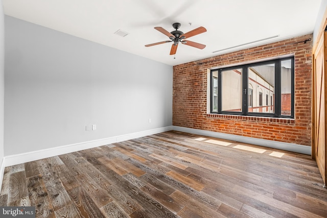 1000 Fell St Unit 633, Baltimore, MD 21231 - unfurnished room with brick wall, wood finished floors, ceiling fan, and baseboards