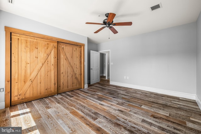 1000 Fell St Unit 633, Baltimore, MD 21231 - unfurnished bedroom with dark wood-style floors, baseboards, and a ceiling fan