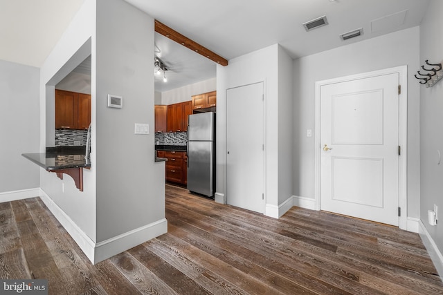 1000 Fell St Unit 633, Baltimore, MD 21231 - kitchen with freestanding refrigerator, dark countertops, tasteful backsplash, a peninsula, and a kitchen bar