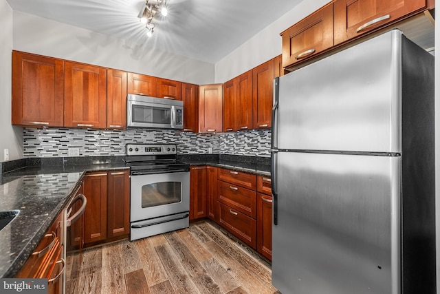 1000 Fell St Unit 633, Baltimore, MD 21231 - kitchen featuring stainless steel appliances, dark wood-style floors, decorative backsplash, and dark stone counters