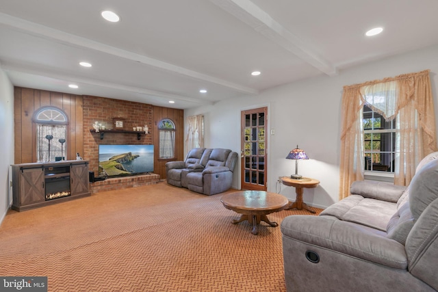 carpeted living area featuring baseboards, beamed ceiling, a brick fireplace, and recessed lighting