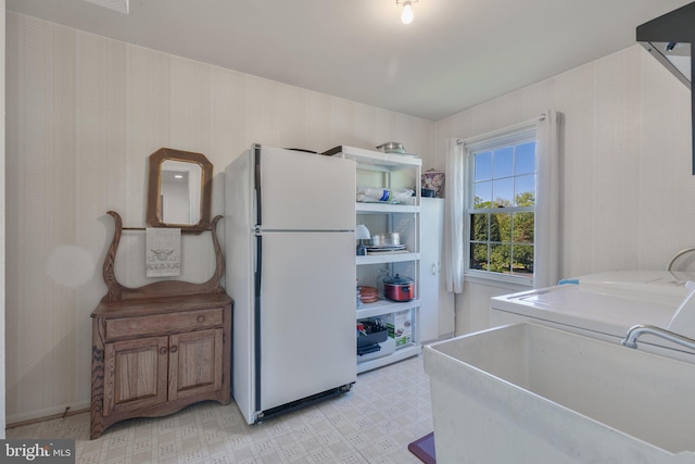 laundry area with washer / clothes dryer, laundry area, a sink, and light floors