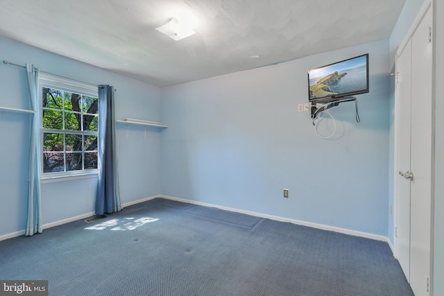carpeted empty room featuring baseboards and visible vents