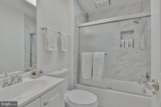 bathroom with vanity, toilet, and shower / bath combination with glass door