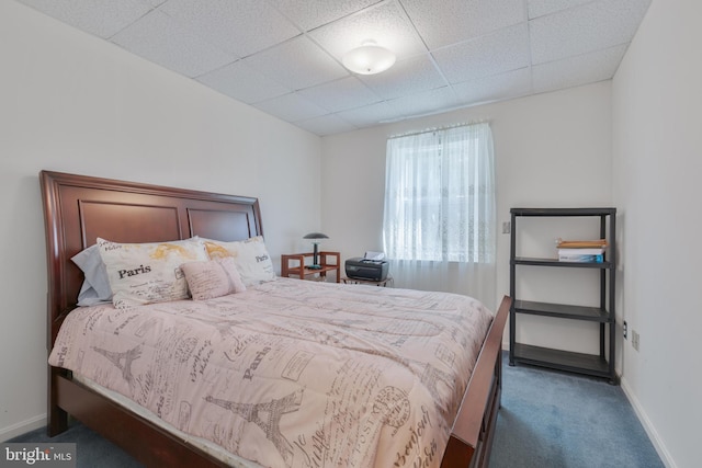 bedroom with baseboards, carpet, and a paneled ceiling