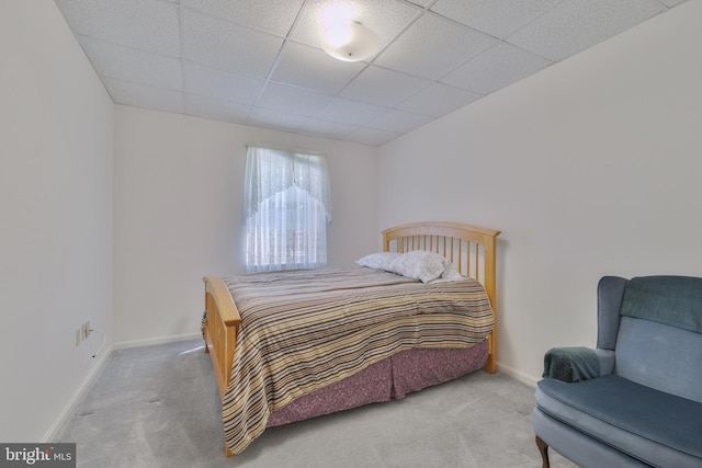 carpeted bedroom with baseboards and a drop ceiling