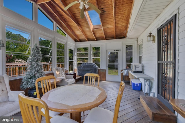 sunroom with a skylight, beamed ceiling, and a ceiling fan