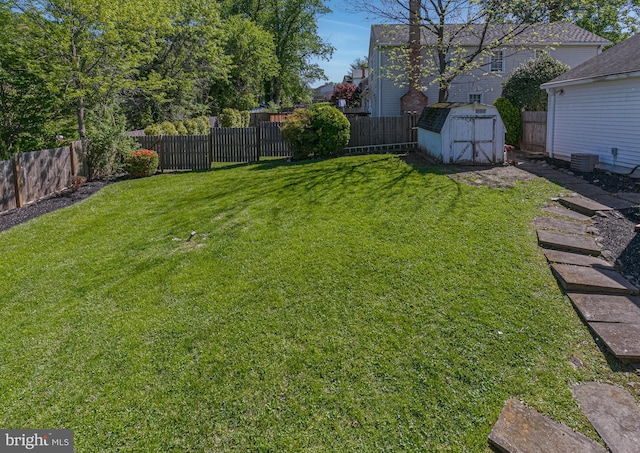 view of yard with a fenced backyard, an outbuilding, and a shed