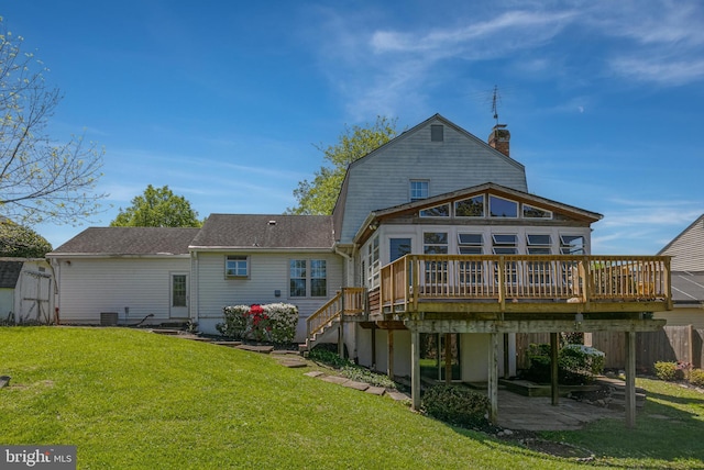 rear view of property featuring a chimney, a deck, stairway, fence, and a yard