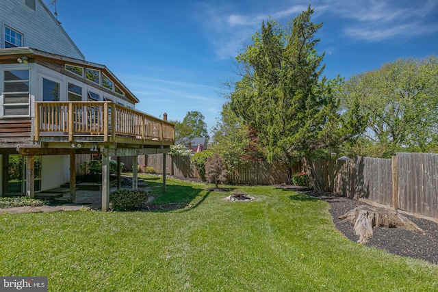 view of yard with a deck, a fenced backyard, a patio area, and an outdoor fire pit