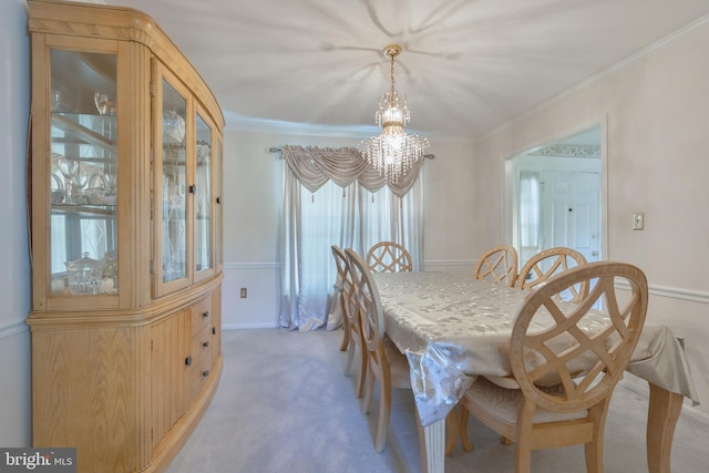 dining room with crown molding, baseboards, an inviting chandelier, and light carpet