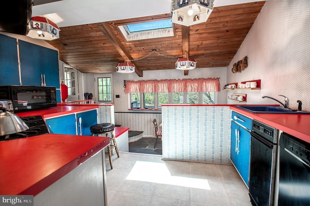 kitchen with a sink, black appliances, and blue cabinetry