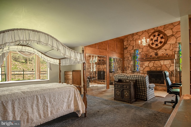 bedroom featuring a stone fireplace, stone finish floor, and high vaulted ceiling