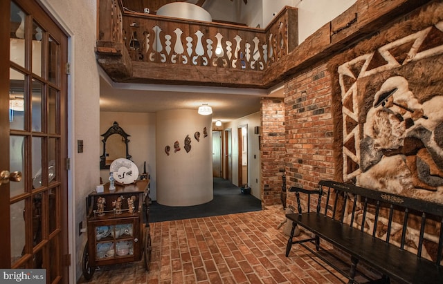 corridor with brick floor and a towering ceiling