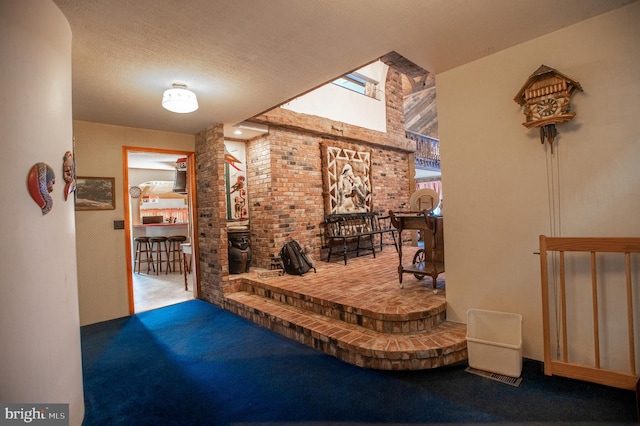 hallway featuring a textured ceiling, carpet, and brick wall