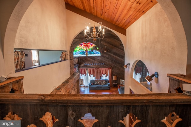 bar with an inviting chandelier, arched walkways, wooden ceiling, and high vaulted ceiling