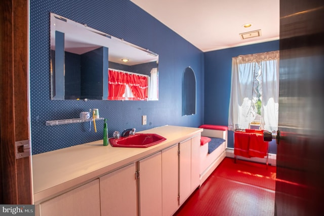 bathroom featuring a healthy amount of sunlight, vanity, and baseboard heating
