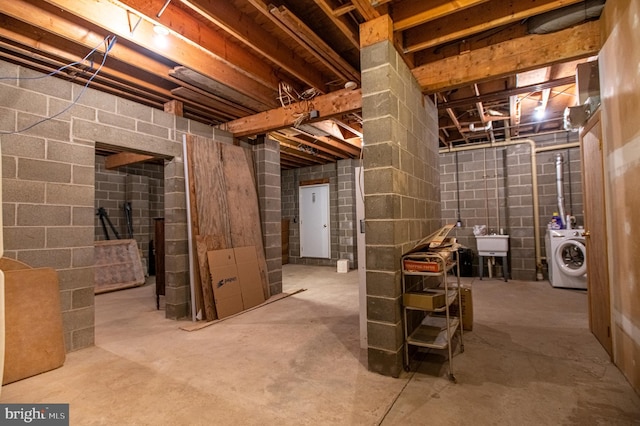 unfinished basement featuring washer / dryer and a sink