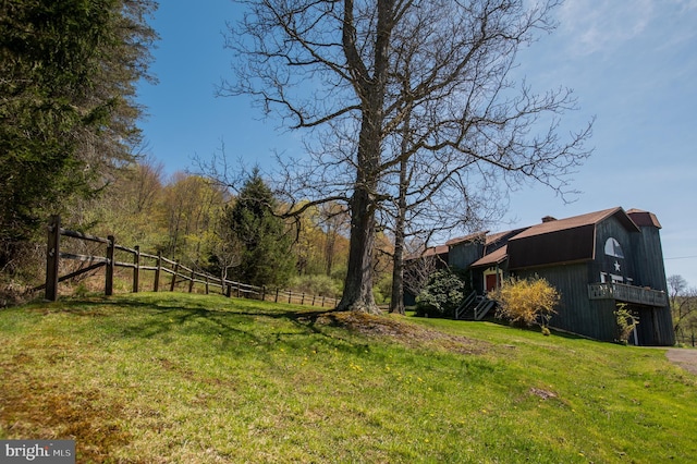 view of yard featuring a barn and fence