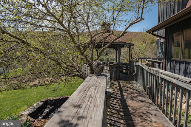 wooden terrace with a gazebo and a lawn