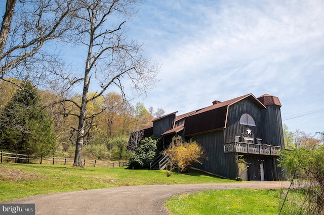 view of property with fence, a barn, and dirt driveway