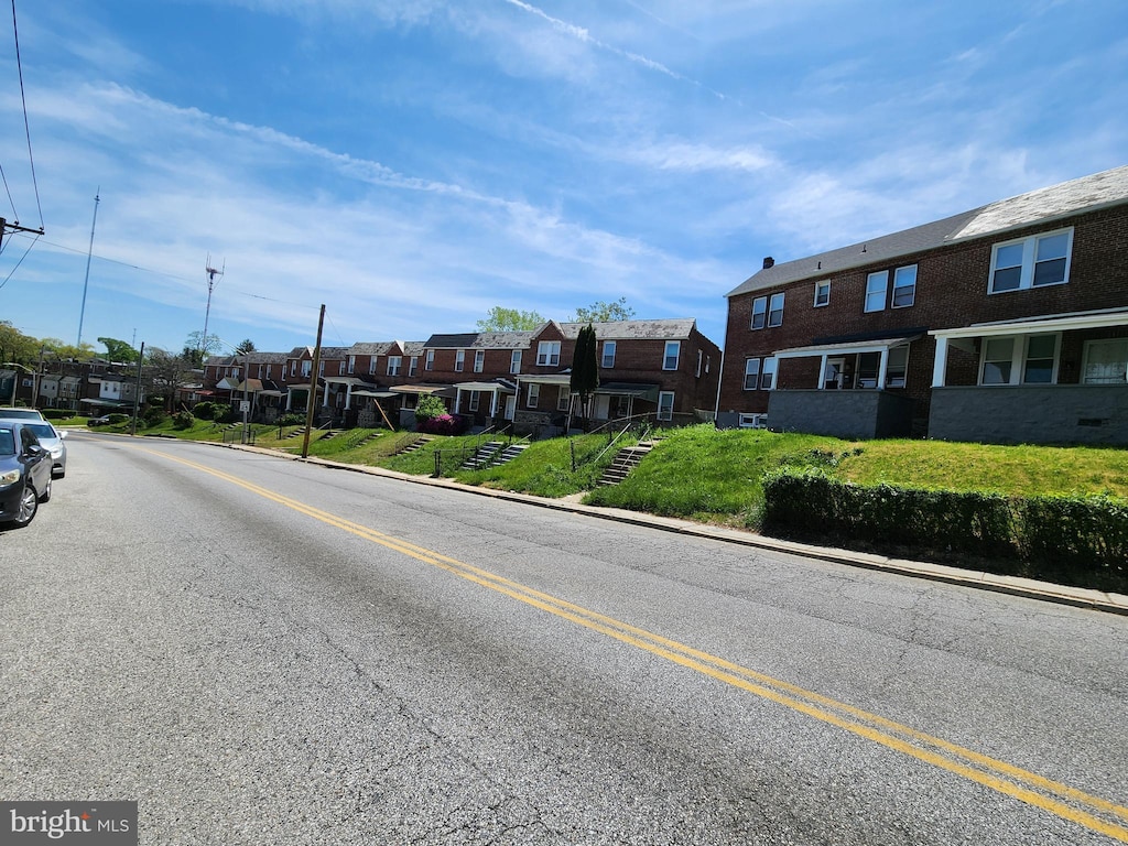 view of road with a residential view, sidewalks, and curbs