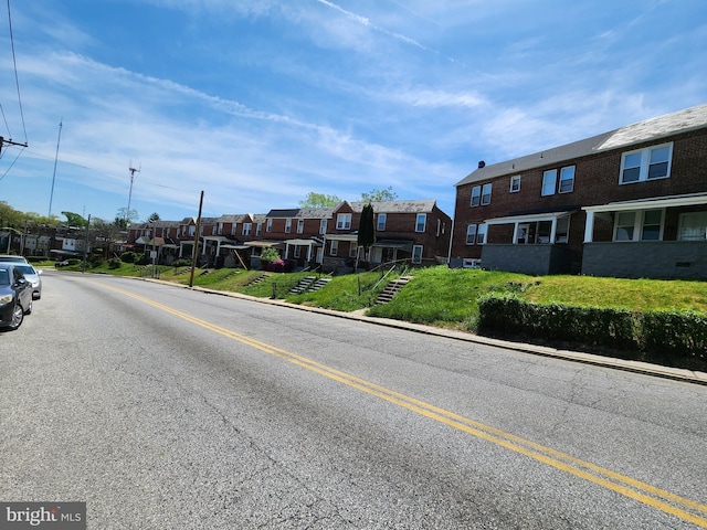 view of road with a residential view, sidewalks, and curbs
