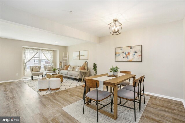 dining room featuring an inviting chandelier, baseboards, and wood finished floors