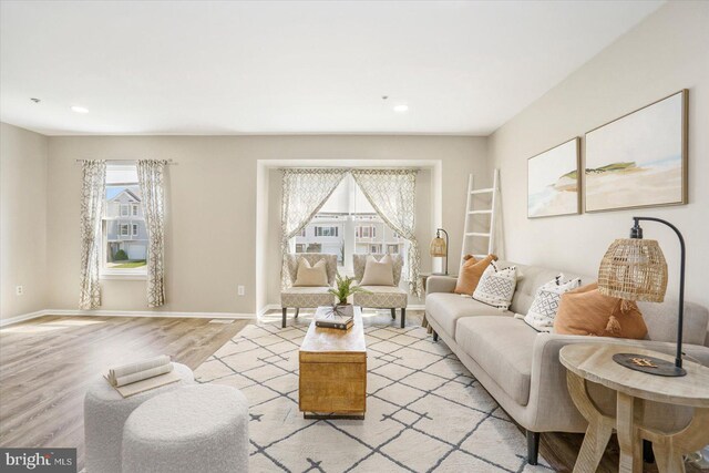 living room featuring a healthy amount of sunlight, baseboards, light wood-style floors, and recessed lighting