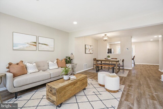 living room with recessed lighting, baseboards, visible vents, and light wood-style flooring