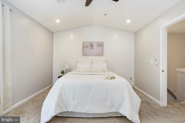 bedroom with light colored carpet, a ceiling fan, baseboards, and vaulted ceiling