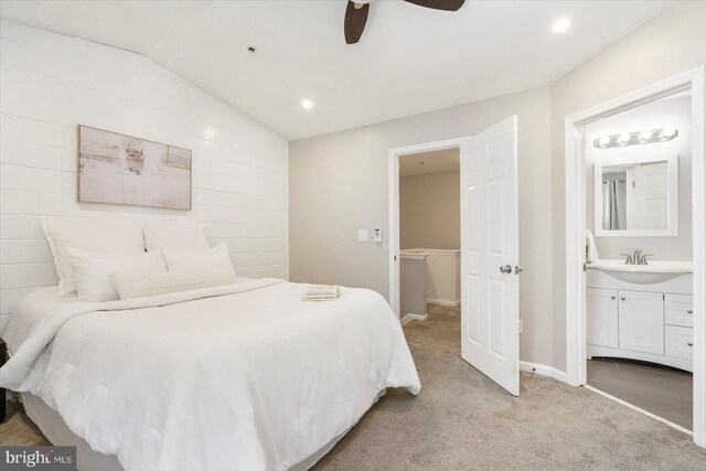 bedroom with lofted ceiling, light carpet, recessed lighting, a sink, and ensuite bath