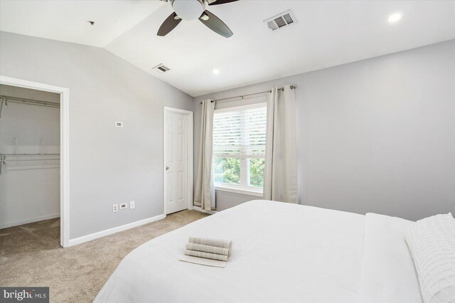 carpeted bedroom with baseboards, visible vents, a spacious closet, and lofted ceiling