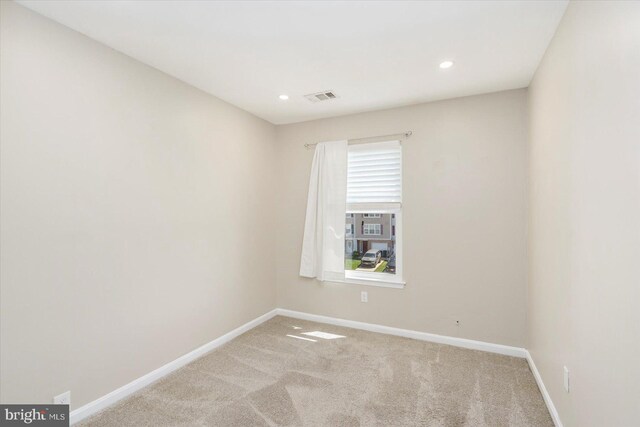 spare room featuring carpet floors, recessed lighting, baseboards, and visible vents