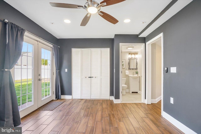 unfurnished bedroom with access to outside, baseboards, wood finished floors, and french doors