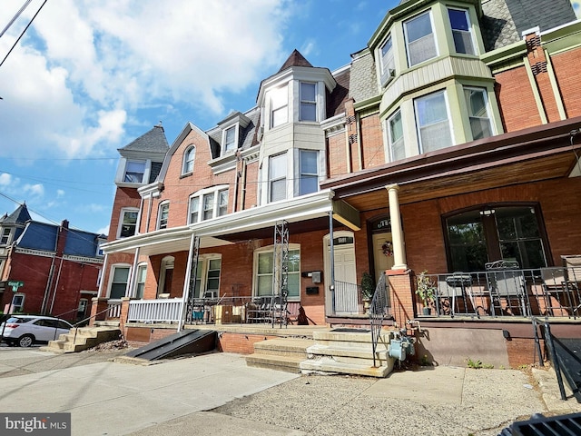 view of front of house featuring a porch and brick siding