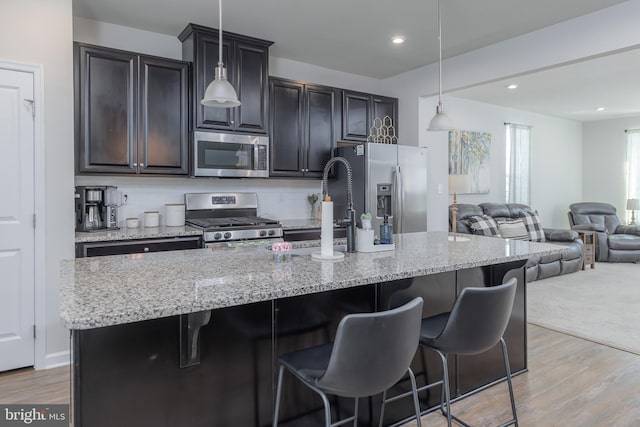 504 Sammy St, Woolwich Twp, NJ 08085 - kitchen featuring open floor plan, light wood finished floors, a kitchen island with sink, and stainless steel appliances
