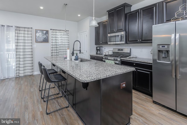 504 Sammy St, Woolwich Twp, NJ 08085 - kitchen with appliances with stainless steel finishes, a sink, light wood finished floors, a breakfast bar area, and a center island with sink