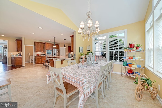 dining space featuring baseboards, a chandelier, light tile patterned floors, and vaulted ceiling