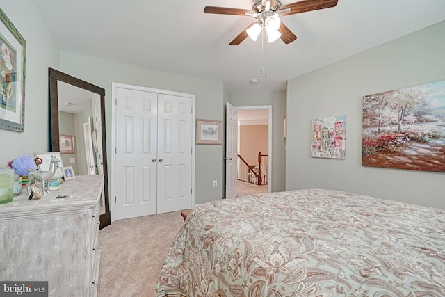 bedroom with ceiling fan, light carpet, and a closet